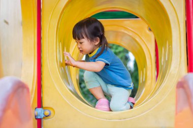 Asyalı öğrenci odadaki kağıda renkler çiziyor ve boyuyor. Evden eğitim, sosyal uzaklık, çocuk ve eğitim konsepti. 2-3 yaş arası çocuk portresi.