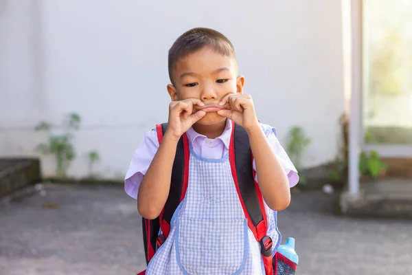 制服姿のアジア系の学生少年は悲しい 彼の手は口を閉じて — ストック写真