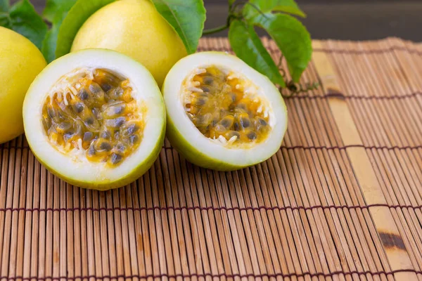 Ada Buah Buahan Passion Kuning Dengan Daun Hijau Latar Meja — Stok Foto