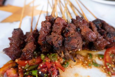 Tipik Endonezya yemeklerinden biri satay ya da doygunluktur. Bu yemek et, koyun eti ya da tavuktan yapılır. Dumanlı kömürlerin üzerinde ızgara yapılır. Sonra da fıstık sosu ve soya sosuyla servis edilir..