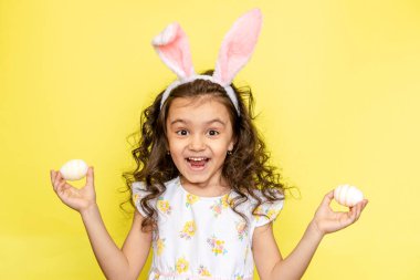 Sarı arka planda paskalya tavşanı kulakları olan neşeli bir kız.