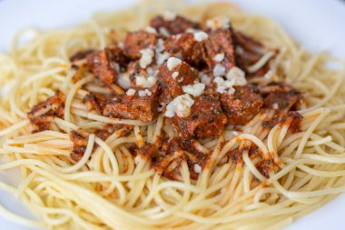 Beyaz tabakta kıymalı spagetti.