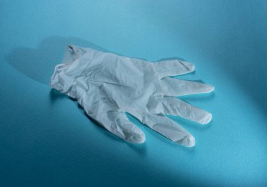 Mavi arka planda tıbbi eldivenleri kapatın.