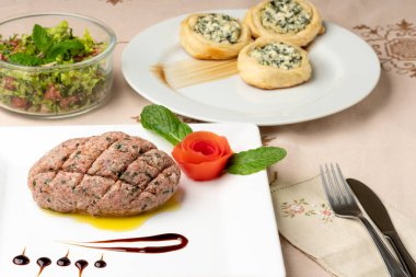 Beyaz bir tabakta çiğ kibbe. Arap mutfağının tipik gıdası.