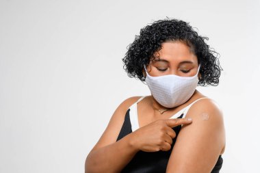 black woman smiling happily and showing the vaccine mark on her arm