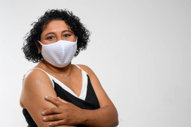 black woman smiling happily and showing the vaccine mark on her arm