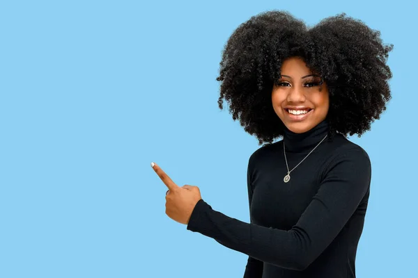 Portræt Smilende Ung Afro Pige Peger Venstre Side Isoleret Blå - Stock-foto