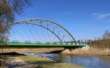 Suprasl Nehri üzerindeki yeşil ve gri çelik köprü. Beyaz ve mavi korkuluklar