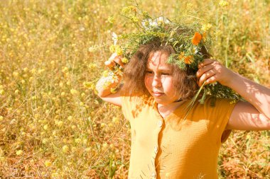 Sahada başında çelenk olan kız..