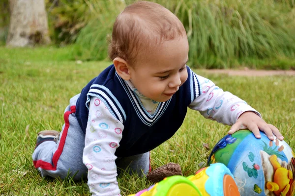 Kid i parken leker med en boll. — Stockfoto