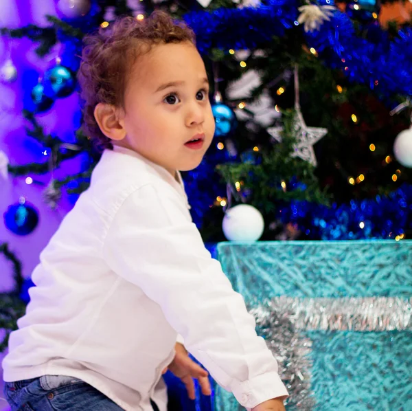 Kind in de buurt van de kerstboom. — Stockfoto