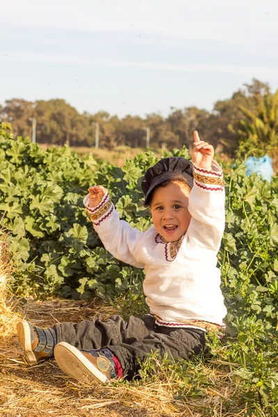 Child playing in a haystack. — Stock Photo, Image