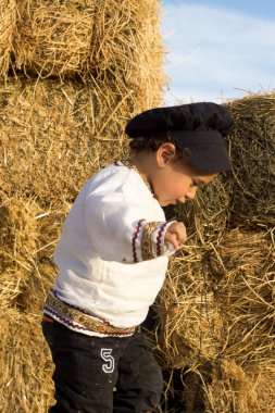 Samanlıkta oynayan çocuk.