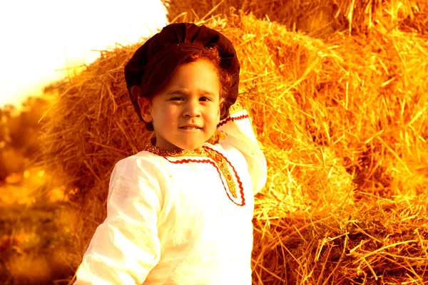 Enfant jouant dans une botte de foin . — Photo