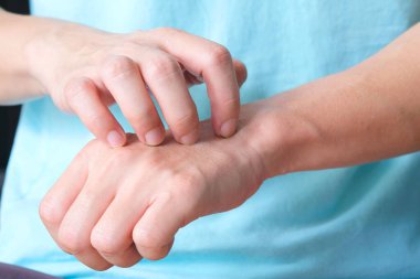 Adamın ellerini sırtını kaşımak için kullanıyor. Deri iltihabı ve kaşıntı hissi yüzünden..