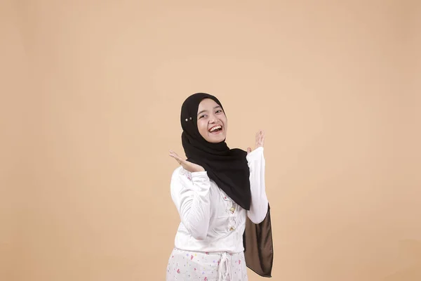 幸せな若いイスラム教徒のアジアの少女の肖像画大きな口を開けて オレンジの背景の上にハード笑っている インドネシア人女性 — ストック写真