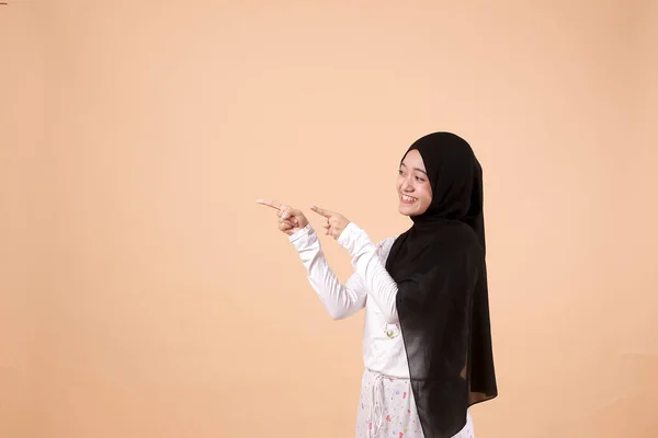 若いアジア系イスラム教徒の幸せな女性の肖像画笑顔と彼女の側に何かを提示することを指す コピースペースと インドネシア人女性 — ストック写真
