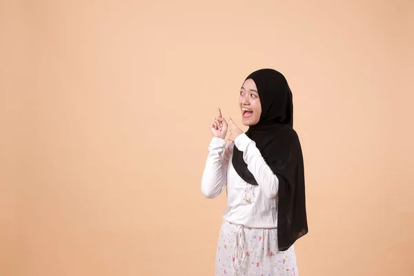 若いアジア系イスラム教徒の幸せな女性の肖像画笑顔と彼女の側に何かを提示することを指す コピースペースと インドネシア人女性 — ストック写真