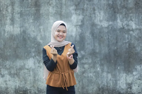 彼女の手で愛やハートサインジェスチャーを作り カメラで笑顔アジアのイスラム教徒の女性の肖像画 — ストック写真