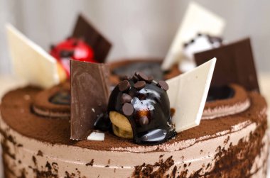 Çikolatalı keki yakın plan süslemek, siyah ve beyaz çikolata dilimli çikolatayla doldurulmuş bir top.