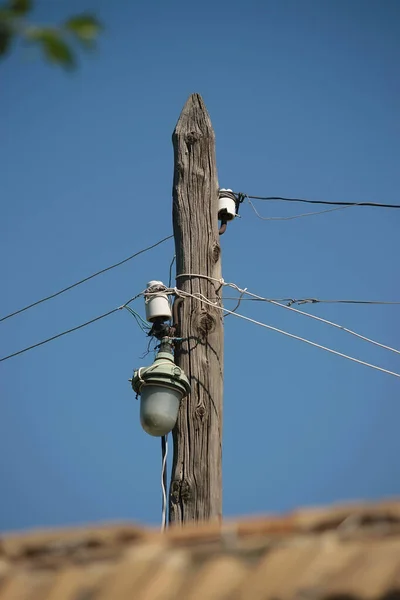 一条旧的木制电线杆上的电线 白天在蓝天的映衬下点亮街道照明 — 图库照片