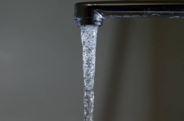 Kabarcıklı su musluktan aşağı akıyor.