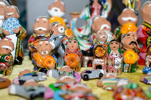 stock image Traditional ceramic figurines of happy Uzbek men and women in national clothes with bread in hands