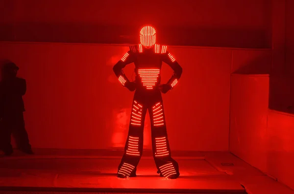 One dancer in a red LED costume dances on a red background