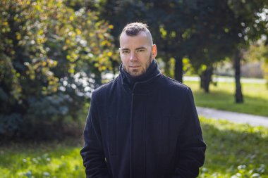 Yerel bir parkta bir adam duruyor.