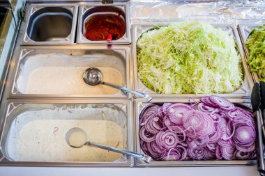 Yerel bir pizza ve jiroskop restoranında sebze reyonunda.