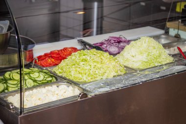 Yerel bir pizza ve jiroskop restoranında sebze reyonunda.