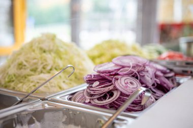 Yerel bir pizza ve jiroskop restoranında sebze reyonunda.