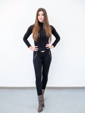 Smiling beautiful young woman standing over white wall