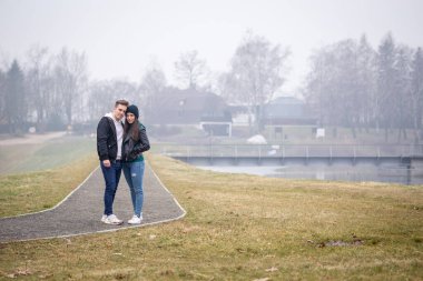Genç çift, Macaristan 'ın Zalaegerszeg kentinde sisli bir kış gününde Gebart Gölü' nde birlikte vakit geçiriyorlar.