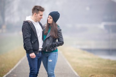 Genç çift, Macaristan 'ın Zalaegerszeg kentinde sisli bir kış gününde Gebart Gölü' nde birlikte vakit geçiriyorlar.