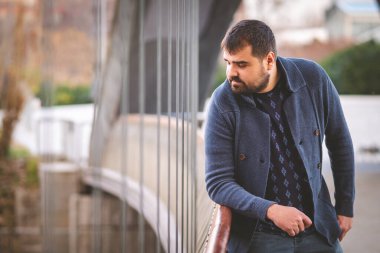 Olgun sakallı adam gün batımında Madrid Köprüsü 'nün korkuluklarına yaslanıyor..