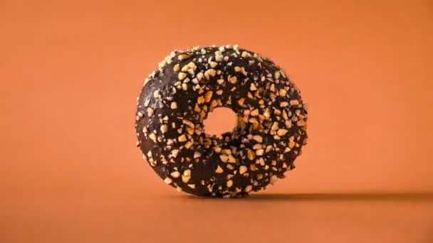 Chocolate Donut Almonds Topping Rotating Orange Background — Wideo stockowe