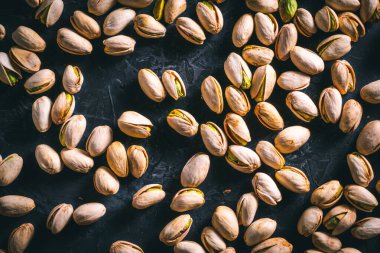 Fıstıklar karanlık bir masaya saçılmış. Fındık yemeye hazır. Enerji gıdası. 