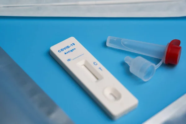 Antijen testi ayrıca test kaseti, pamuk çubuğu ve mavi bir yüzey üzerinde örnek tüp ile Corona hızlı testi. Sıvıya odaklan. Yakın çekim..