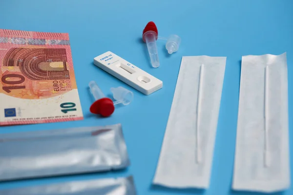 Antijen testi ayrıca test kaseti, pamuk çubuğu ve mavi bir yüzey üzerinde örnek tüp ile Corona hızlı testi. Paraya odaklan. Yan görünüm.