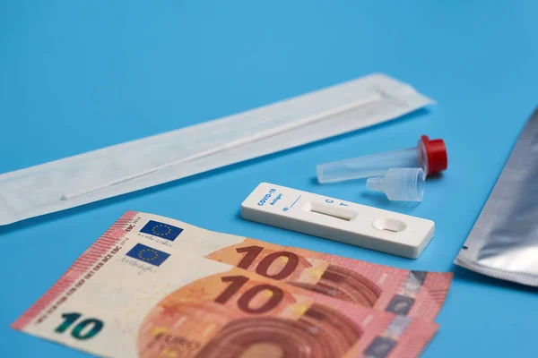 Antijen testi ayrıca test kaseti, pamuk çubuğu ve mavi bir yüzey üzerinde örnek tüp ile Corona hızlı testi. Mavi harflere odaklan. Yan görünüm.