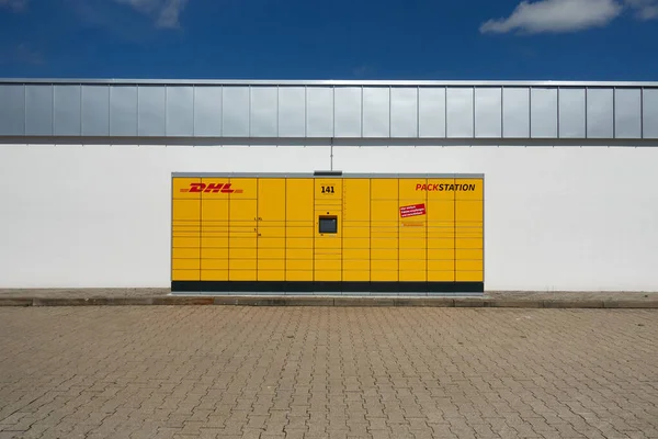 Neckartenzlingen, Almanya - 29 Haziran 2021: Dhl paket makinesi de Packstation. Paketleri gönderip almak için sarı makine. Mavi gökyüzü olan beyaz bir binada. Ön görünüm.