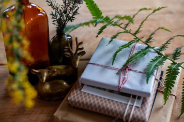 El yapımı hediye, cam şişeler, geyik heykelcikleri, kırsal ahşap arka planda yeşil bitkiler.