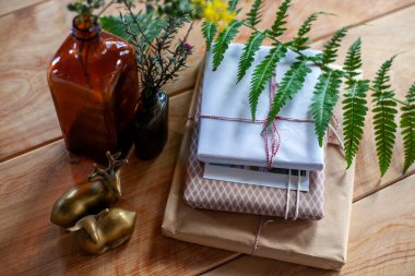 El yapımı hediye, cam şişeler, geyik heykelcikleri, kırsal ahşap arka planda yeşil bitkiler.