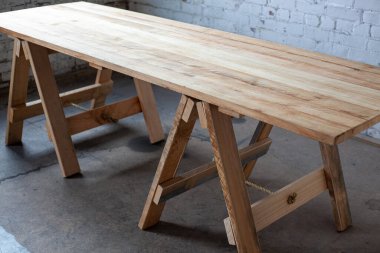 Odanın bacakları üzerinde uzun tahta bir masa.