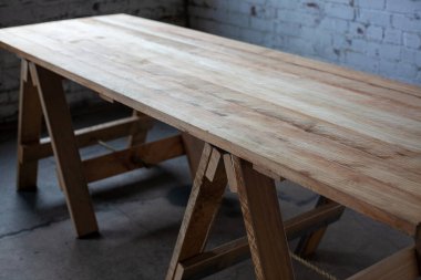 Odanın bacakları üzerinde uzun tahta bir masa.