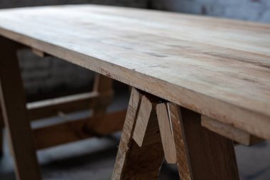 Odanın bacakları üzerinde uzun tahta bir masa.