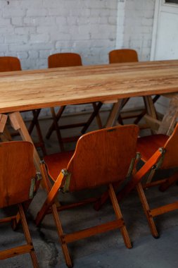 Odaya çıkmak için uzun tahta masa ve sandalyeler.