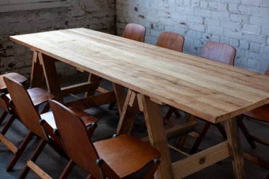 Odaya çıkmak için uzun tahta masa ve sandalyeler.