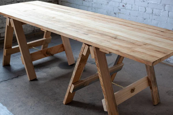 Odanın bacakları üzerinde uzun tahta bir masa.